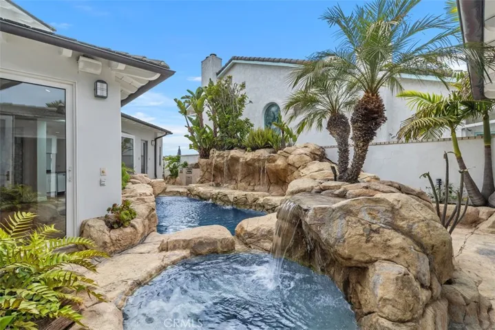 Both pool and spa have waterfall features.  This is a beautiful oasis in your own private secluded yard.  At the end of the pool is an outdoor bathroom.
