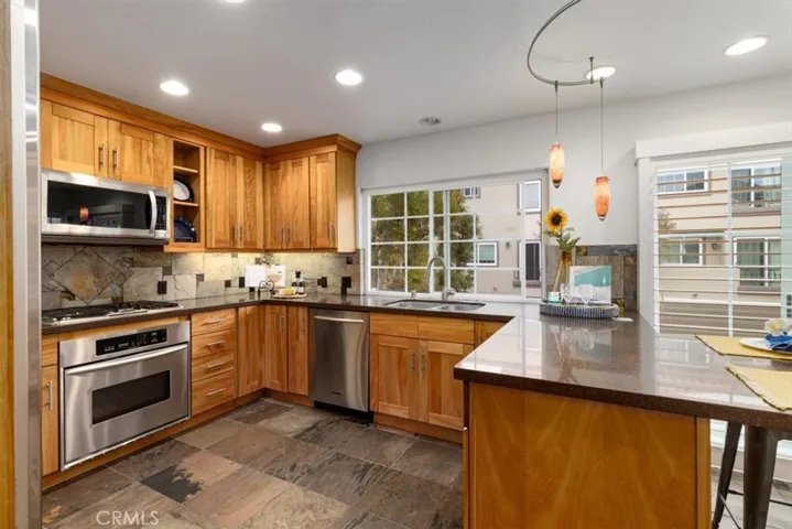Stylish and modern kitchen featuring solid wood cabinets, sleek stainless steel appliances, and a fresh, contemporary coastal vibe—perfect for everyday living and entertaining.