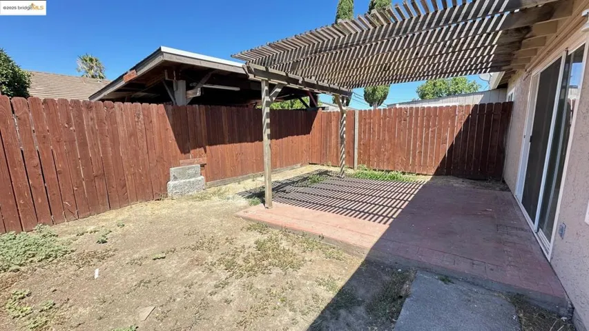 Fenced backyard featuring a patio and a pergola
