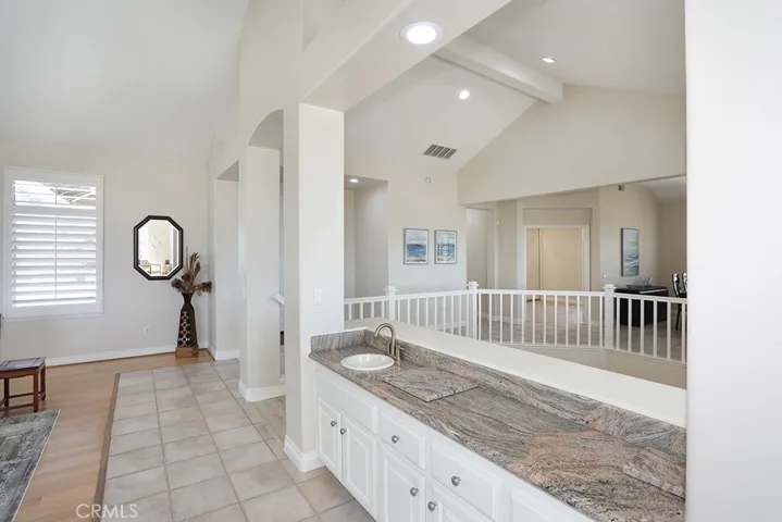 Wet bar in living room facing entry and door way to bedroom