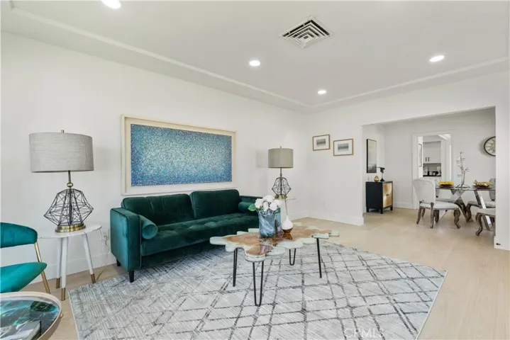 Living room looking towards entry, and dining room in bg