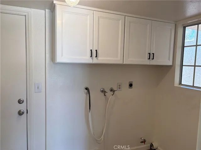 Inside laundry room with storage