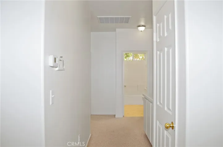 Hall with Alarm, Coat Closet, and Linen Cabinets