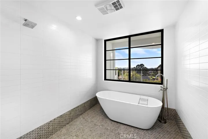 Master bath offers a rain-shower as well as a tub with a picturesque window.