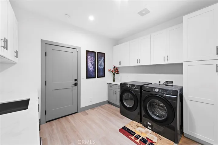 The added main level laundry room with ample cabinets and a sink with direct access to the 3 car garage.