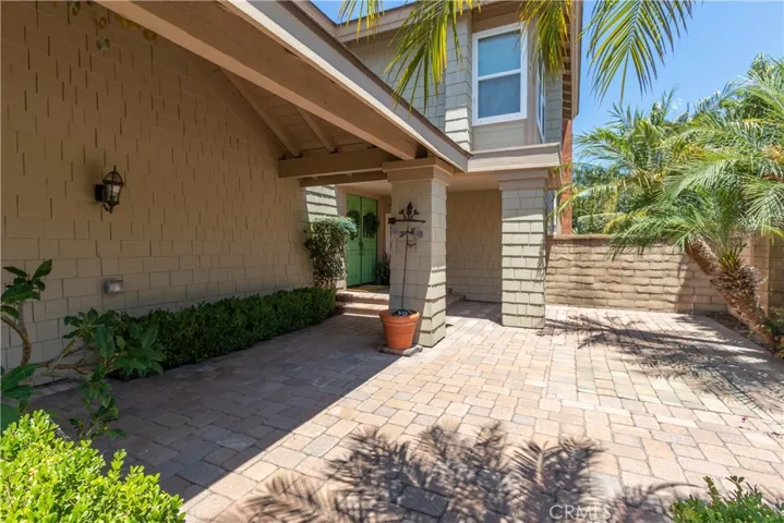 Paver patio in front surrounded with garden beds.