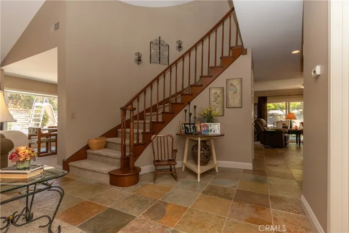 Sweeping staircase near the entry leads to bedrooms and bonus room upstairs.