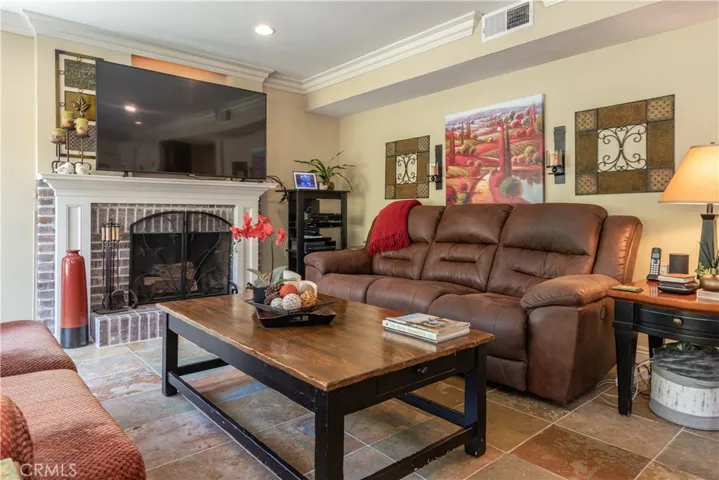 Slate tile floor, recessed lighting and crown molding in the family room.