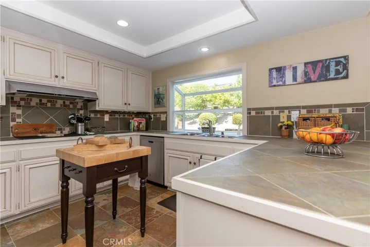 White cabinets and slate floor in the kitchen.
