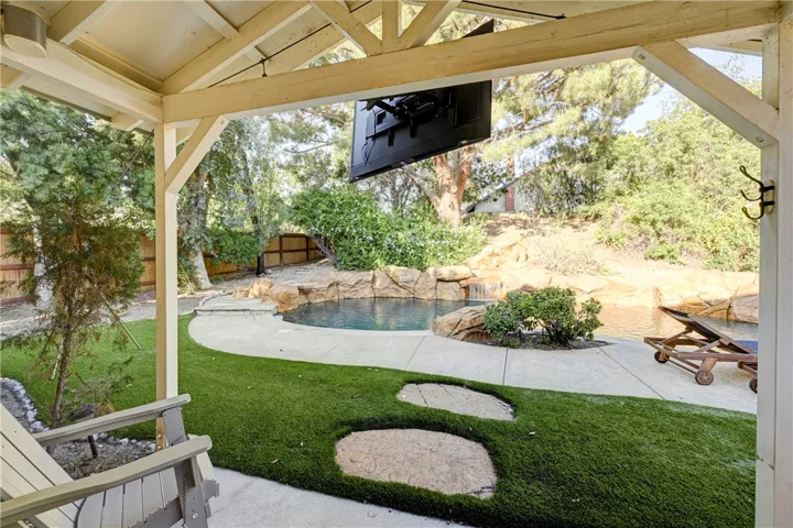 Your view from the primary bedroom to the pool and relaxing waterfall.