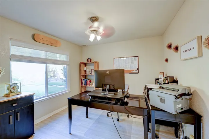 Downstairs bedroom with double door entry, ceiling fan and a beautiful view to the backyard.