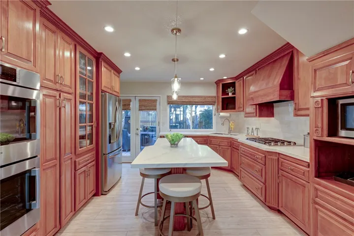 Beautiful kitchen with stainless steel appliances, recessed lighting and French doors to the backyard.