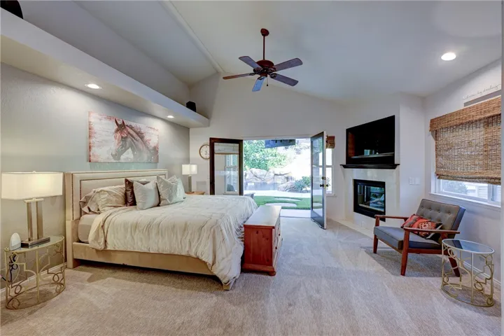 Downstairs Primary Suite with French doors looking out to the beautiful backyard with pool and waterfall.