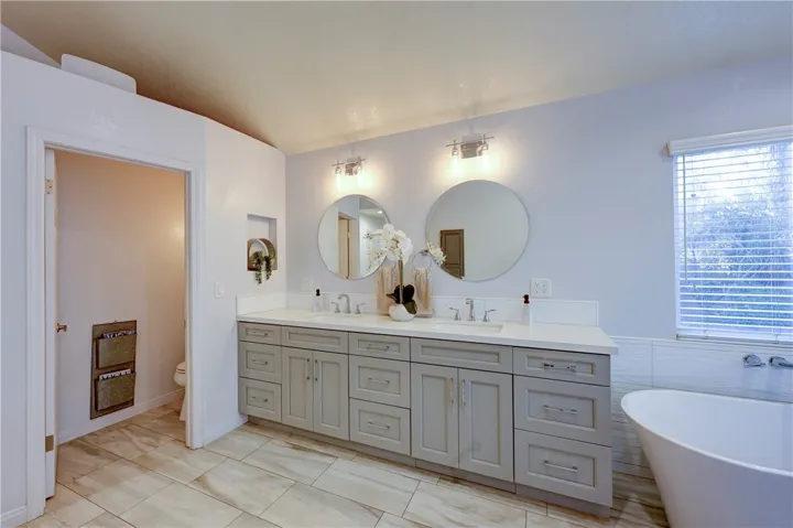 Primary bath with privacy toilet and double sinks.