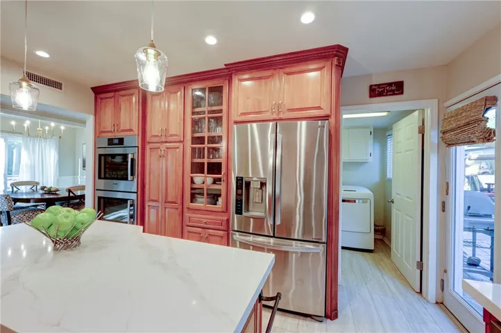 Note the double oven, glass cabinetry and easy access to the laundry room.