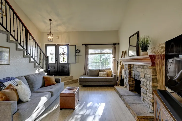 Your view from the dining room to the living room with the beautiful stone fireplace with hearth and mantle.