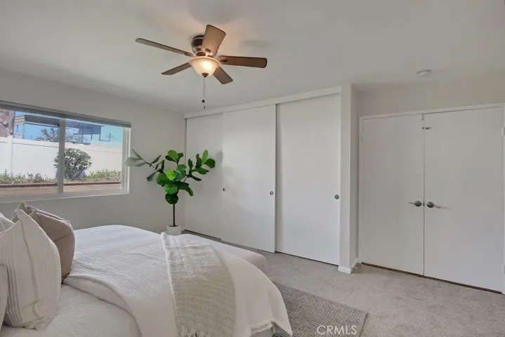 Primary bedroom with dual closets, double-door entry, and serene backyard views—offering both comfort and functionality in a private retreat setting.