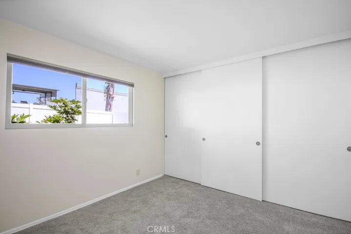 Second bedroom with fresh neutral paint and new carpet.