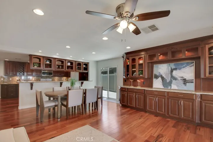 Elegant built-in cabinetry spans the family room, offering stylish storage and display space—perfectly positioned between the dining area and kitchen with easy access to the side patio.