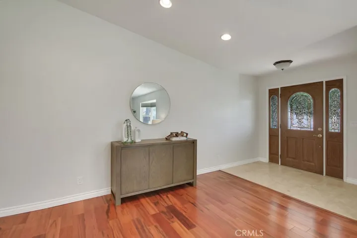 Inviting entry with custom door, recessed lighting, and rich wood floors leading into the main living space.