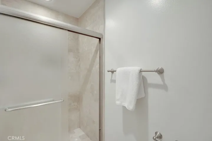 Primary bathroom includes a walk-in shower with tile surround and sliding glass doors—clean, neutral, and move-in ready.