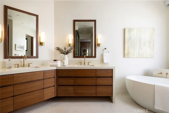 The spa-inspired primary bath features quartzite surfaces, steam shower, freestanding jacuzzi tub, and custom walnut cabinetry.