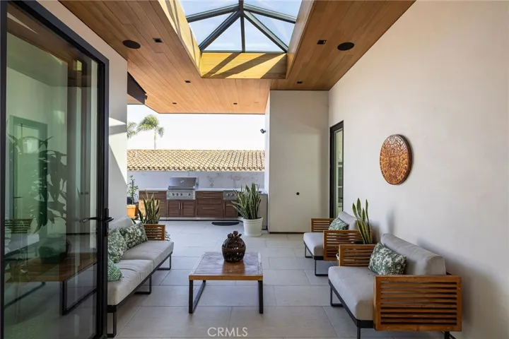 Built in BBQ with porcelain counters, wood-grain metal cabinetry, dual burner, outdoor sink and storage.   