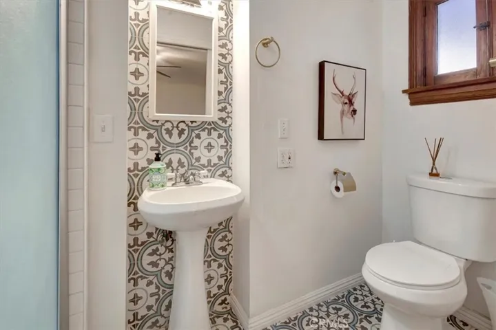Small three-quarter bath with shower and pedestal sink.