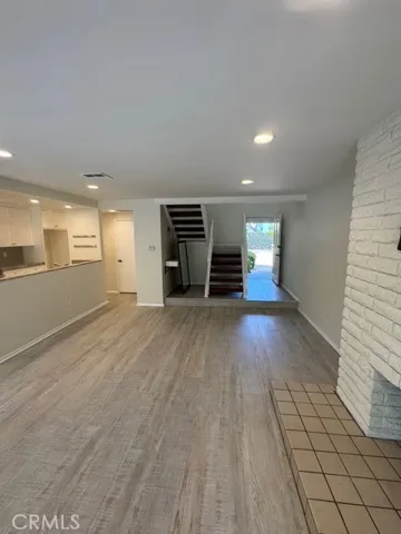 view from fire place and patio to kitchen out to entry and stairs to floor 2