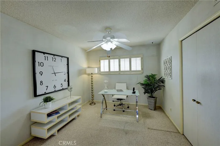 Bedroom #3 Staged as an office has plantation shutters and a lighted ceiling fan.