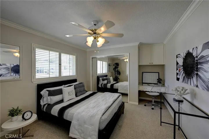 Bedroom #2 has a desk/vanity area, mirrored wardrobe doors, lighted ceiling fan and plantation shutters.