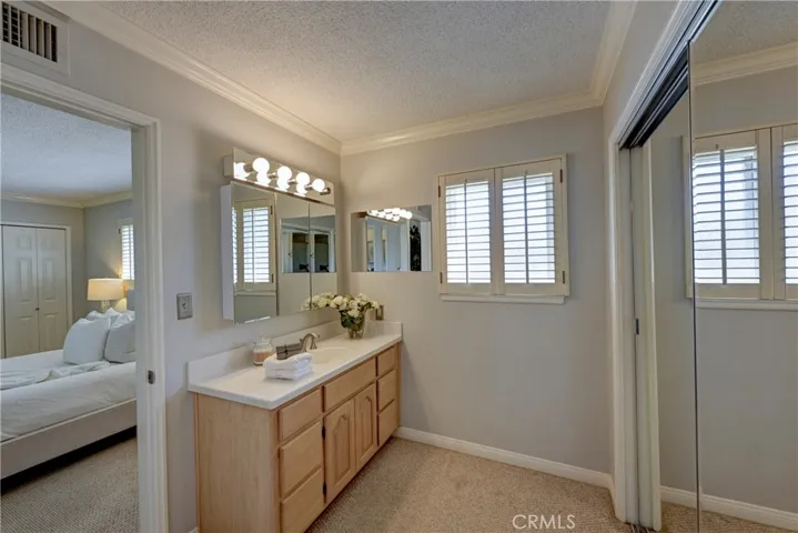 Primary Bath with window and closet with mirrored doors.