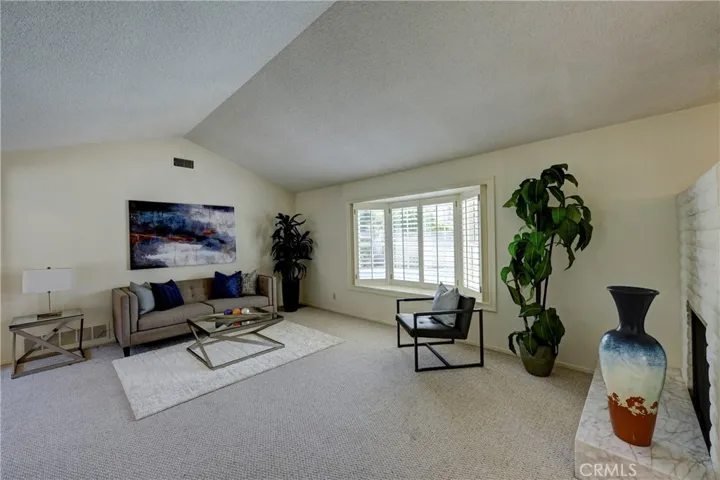 Bay window with plantation shutters look out to the refreshing pool from the formal living room.