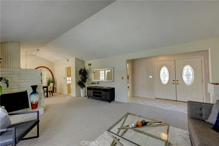 Formal living room has gas starter fireplace and vaulted ceiling.