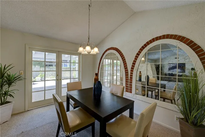 Formal dining room with the reflection of the formal living room in the arched mirrors.