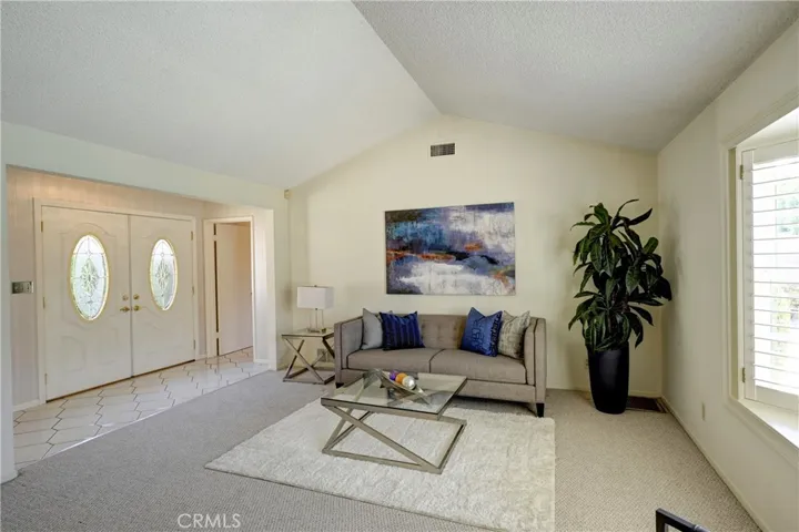 Enter through double doors to lots of natural light and vaulted ceiling in the formal living room.