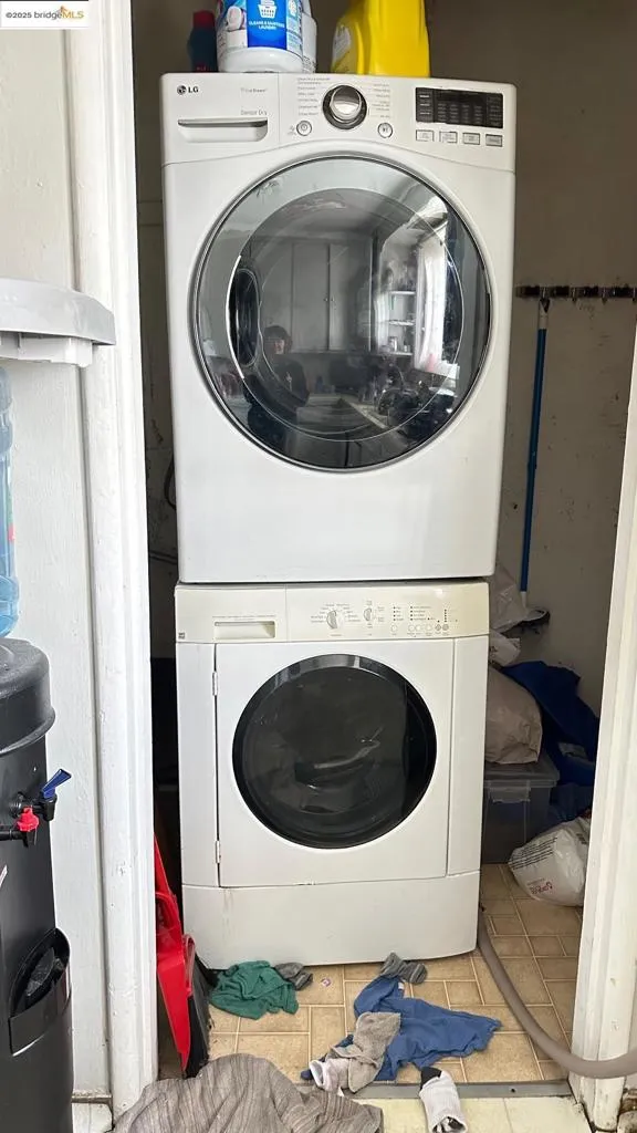Washroom featuring tile patterned flooring and estacked washer and dryer