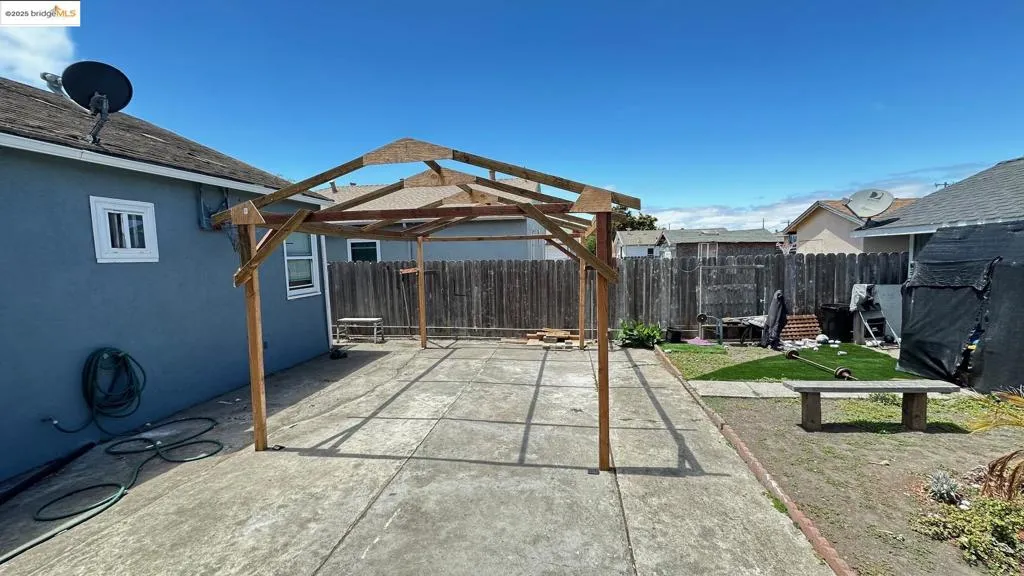 Fenced backyard featuring a patio area and a gazebo