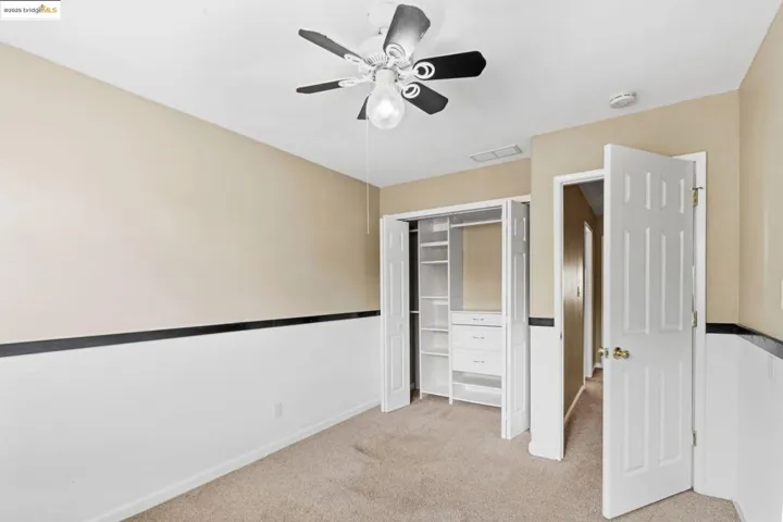 Unfurnished bedroom featuring light carpet, a closet, and a ceiling fan