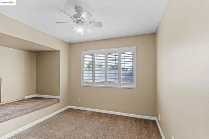 Carpeted spare room featuring a ceiling fan and a textured ceiling