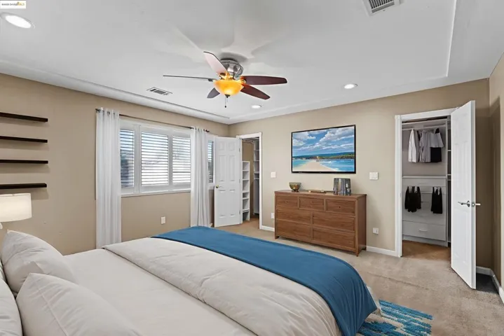 Bedroom with a walk in closet, carpet floors, ceiling fan, and recessed lighting