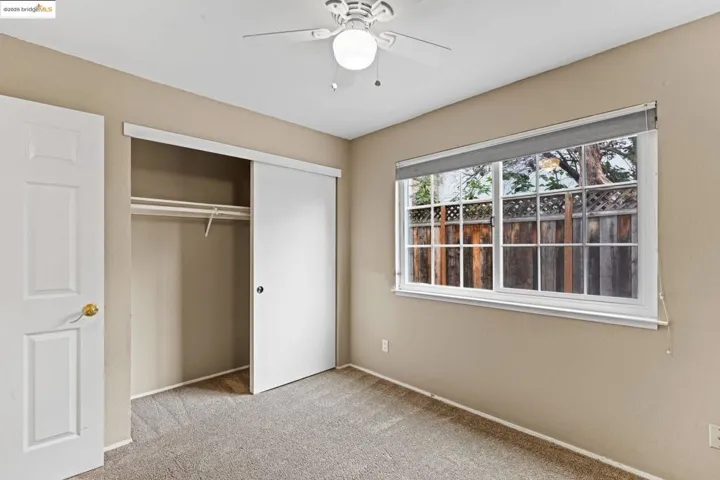 Unfurnished bedroom with carpet floors, a closet, and a ceiling fan