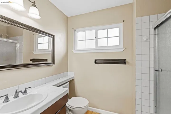 Bathroom with tiled shower and vanity