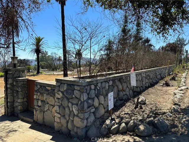 90' river rock wall with gated entry
