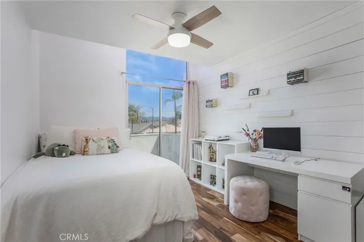 Secondary bedroom with shiplap wall opens to balcony