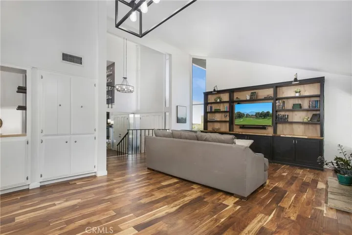 Living room includes custom entertainment center with sconces