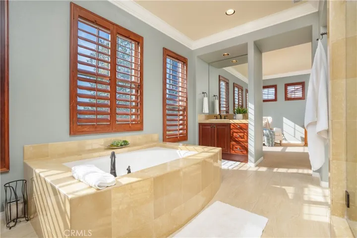 Primary bath with two walk in mirrored closet doors.