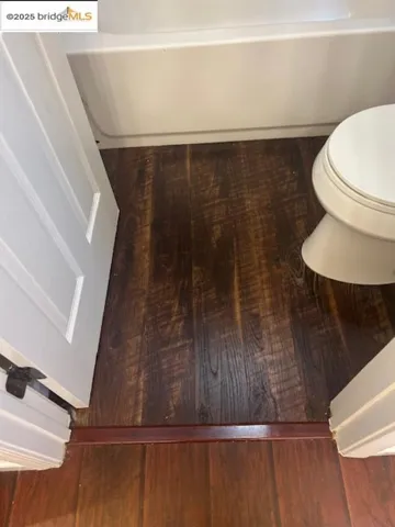 Bathroom view of a tub and wood finished floors