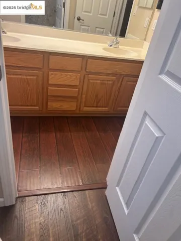 Bathroom featuring double vanity and wood finished floors