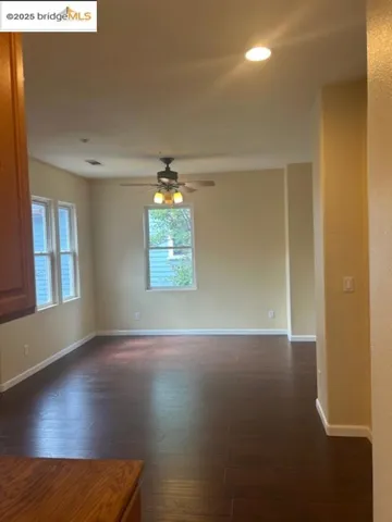 Spare room with plenty of natural light, dark wood-type flooring, ceiling fan, and recessed lighting